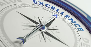 Abbild eines Kompasses, der statt mit den Polbezeichnungen mit Begriffen aus dem Qualitätsmanagement beschriftet ist. Die Kompassnadel zeigt auf die Beschriftung «Excellence».