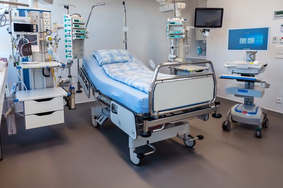 Ein Patientenbett mit zwei Monitoren und weiteren elektronischen Hilfsgeräten.